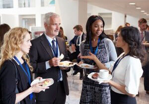 Professionals talking with coffee at a networking event